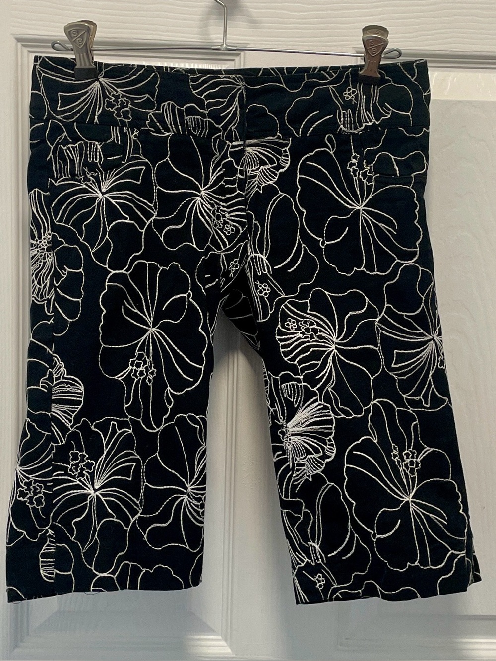 CACHE-embroidered white lotus Bermuda shorts.